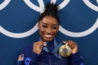 Unveiling the Inspiration: The Meaning Behind Simone Biles’s Iconic Goat Necklace & Ferragamo’s Dramatic Profit Decline